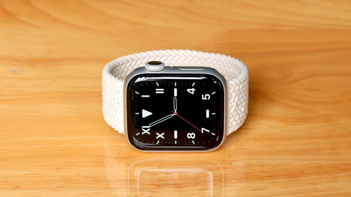 Apple Watch met beige bandje op houten ondergrond