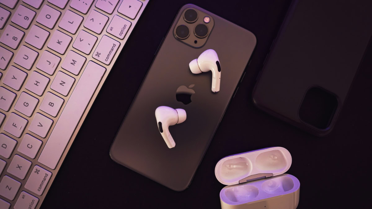 AirPods Pro bovenop iPhone naast toetsenbord