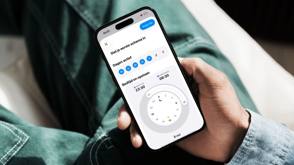 iPhone in hand met slaapschema erop