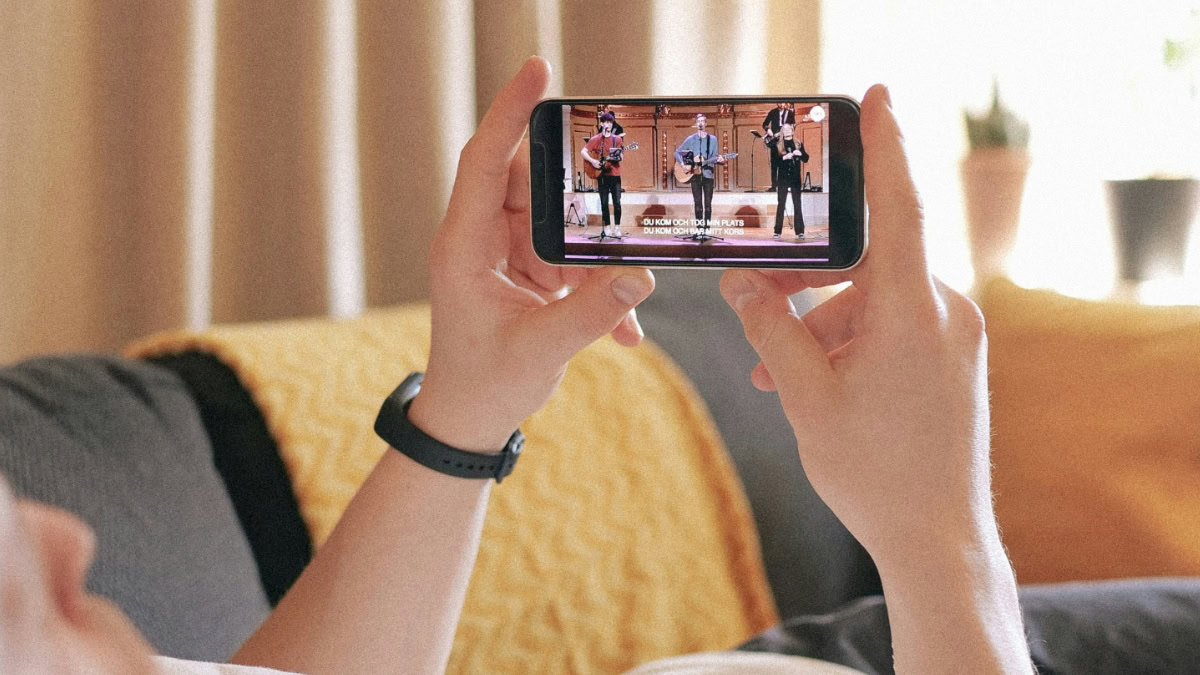 Man op bank met iPhone en filmpje