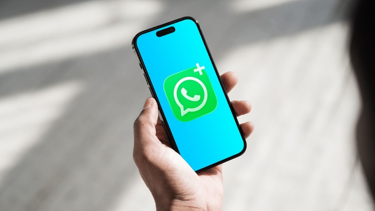 iPhone in hand met zelfgemaakte logo WhatsApp Plus