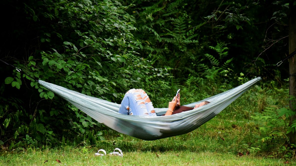 Vrouw in hangmat met iphone