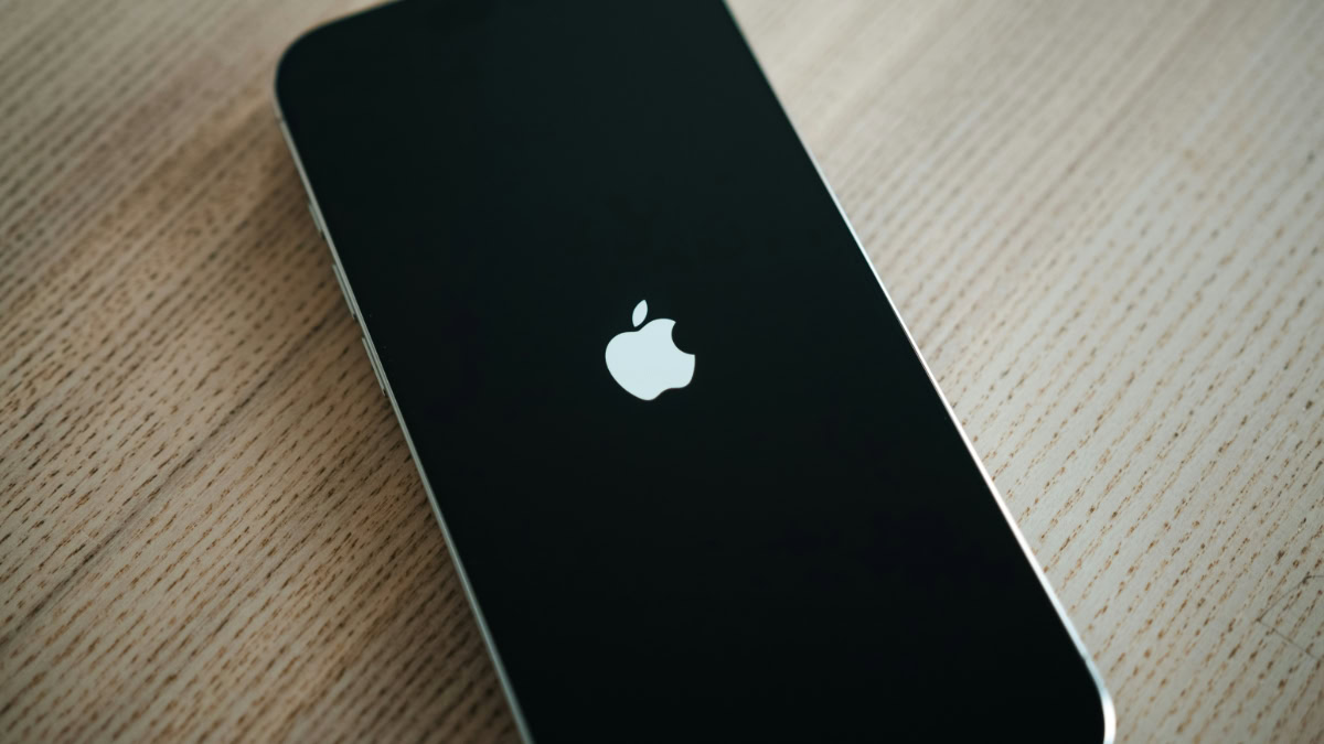 iPhone met opstartscherm op houten tafel