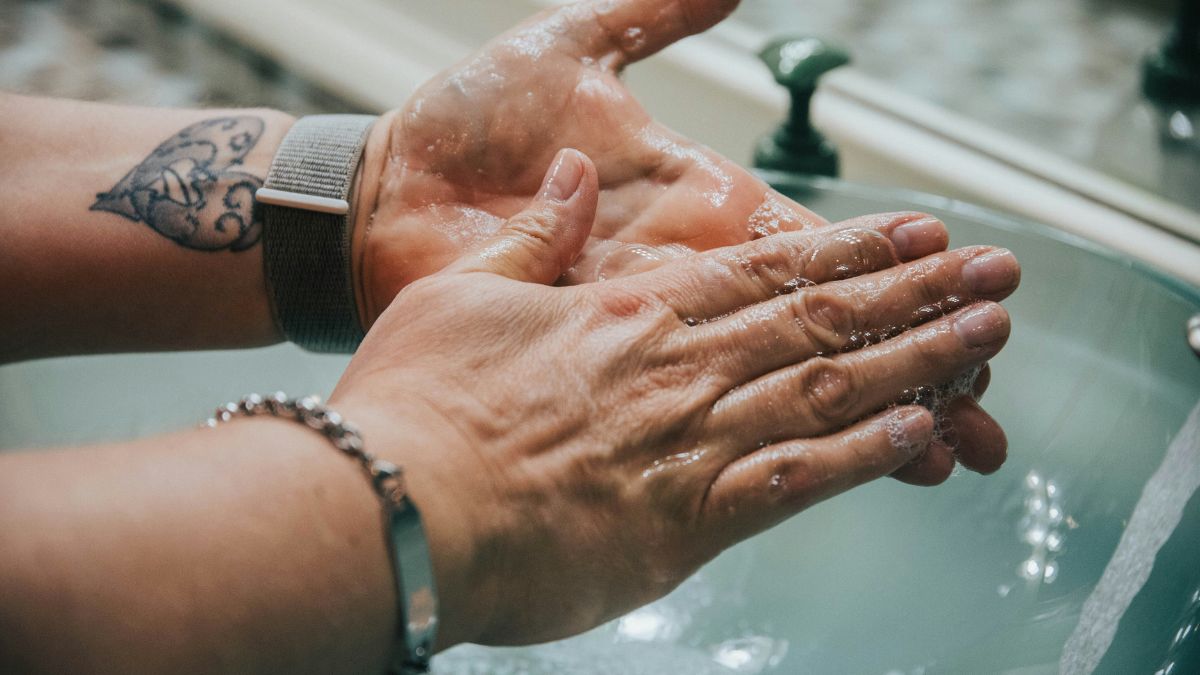 Persoon wast handen en draagt Apple WAtch