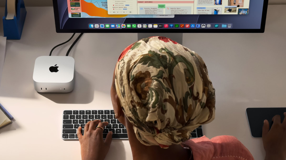 Vrouw achter monitor met Mac mini