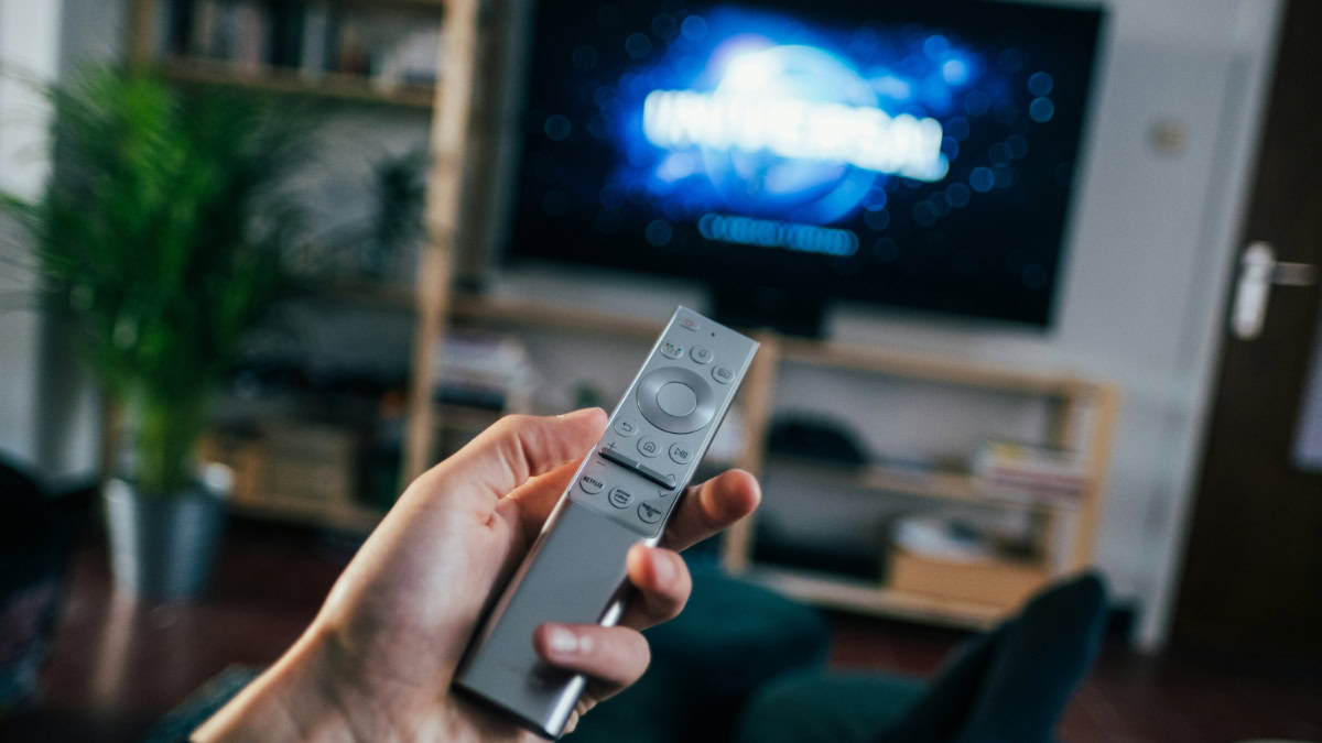 Afstandsbediening in hand voor televisie